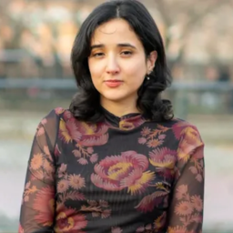 headshot of Bianca Fortis, a woman with black shoulder-length hair with a floral tops on