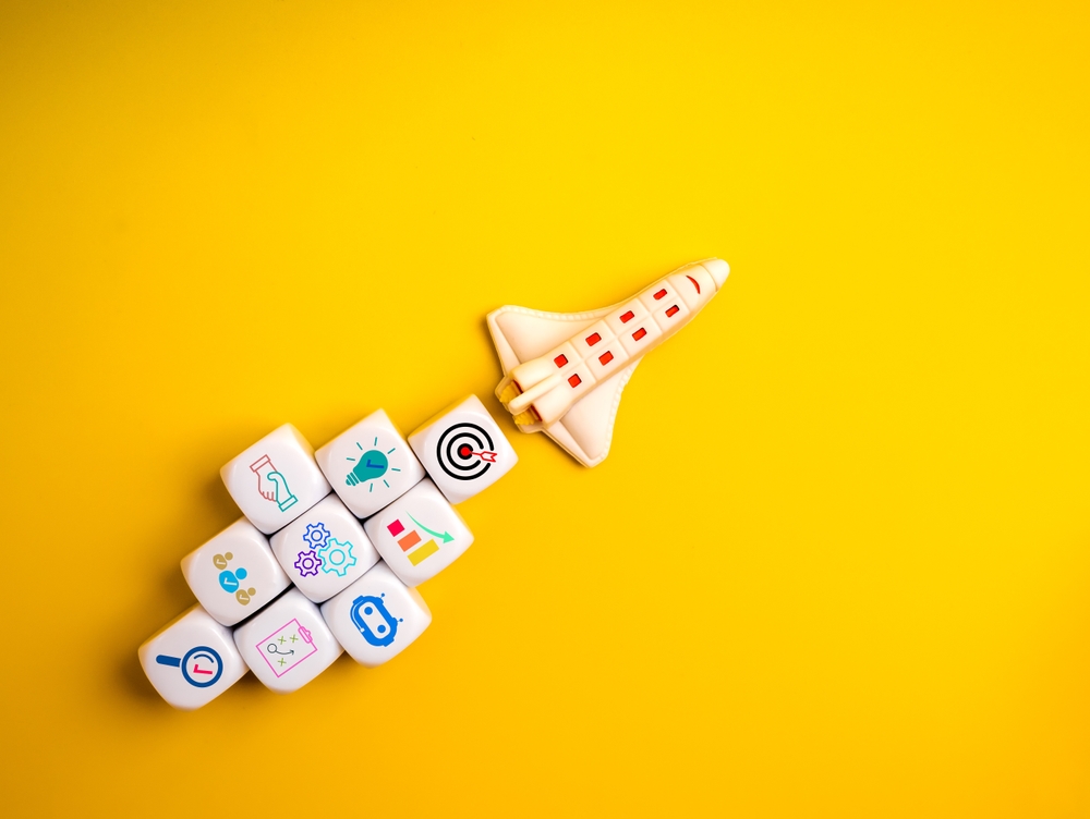 Creative,Rocket,With,Startup,Icons,On,White,Cubes,Over,Yellow
