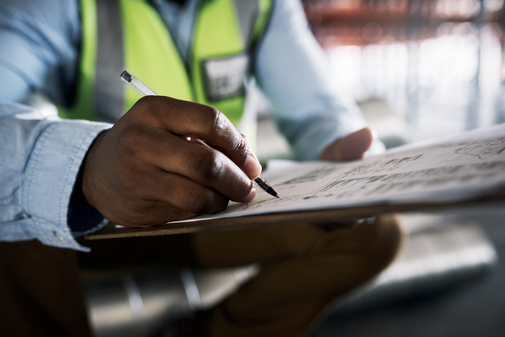 A photo of a man's hands checking things off a list with a pen